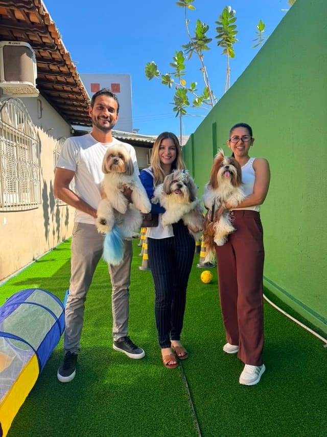 Equipe da Royal Pet com três cães no colo, no espaço de recreação
